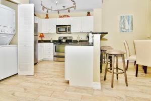 圣徒皮特海滩Madeira Bay Resort 508的厨房配有白色橱柜和桌椅