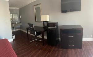 安纳海姆Legacy inn & suites的客房设有一张带电脑和镜子的书桌