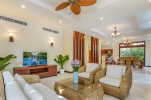 岘港Da Nang Paradise Center My Khe Beach Resort & Spa的客厅配有白色家具和吊扇