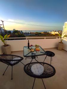 普拉坦斯Poseidonas luxury Apartment的阳台配有玻璃桌和两把椅子