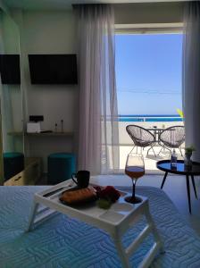 普拉坦斯Poseidonas luxury Apartment的一张带食物和葡萄酒托盘的床