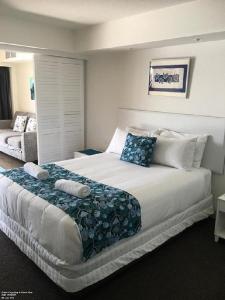 卡伦德拉Just Perfect Apartment with Ocean Views的卧室配有带蓝色枕头的大型白色床