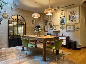 巴塞罗那Vilana Hotel Boutique的一间带木桌和绿色椅子的用餐室