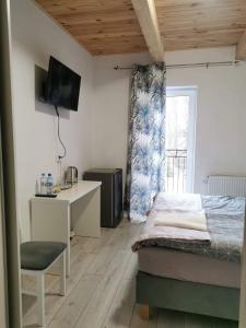 MiałkówekAGRO-Jabłońscy的一间卧室配有一张床、一张书桌和一个窗户。