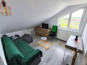 弗洛雷什蒂Quiet and Cozy 2 bedroom flat with free parking included的客厅设有绿色沙发和窗户。