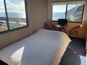 小豆岛1棟貸し tbtランド 定員最大12名的卧室设有一张白色大床和两个窗户。