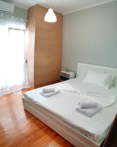 希俄斯Panoramic Apartment的卧室配有带毛巾的大型白色床