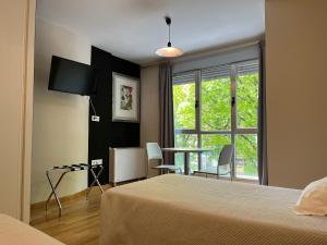 莱昂莱昂公寓的一间卧室配有一张床、一张桌子和一个窗户。