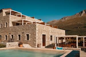 尼奥·奥伊蒂龙Itilo Traditional Hotel的一座石头房子,前面设有一个游泳池