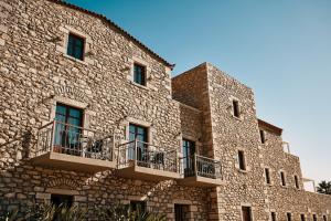 尼奥·奥伊蒂龙Itilo Traditional Hotel的一座石头建筑,旁边设有阳台