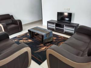 大港Abah StayCation的客厅配有两把椅子和电视
