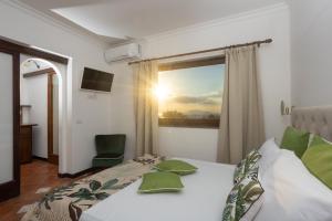 阿纳卡普里Villa Aurora Pool & Fitness的一间卧室设有一张床和一个享有日落美景的窗户