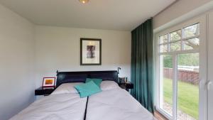 万根沃格Landhaus Lindenhof, Insel-Juwel的一间卧室设有一张床和一个大窗户