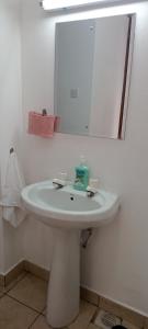 蒙巴萨Lyneks Cosy Apartment的浴室设有白色水槽和镜子