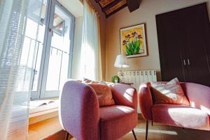 斯波莱托HEART OF SPOLETO Vacation Residence的客厅配有两把椅子和窗户