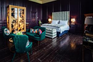纳文贝林塔大厦酒店的一间卧室配有一张床、一把椅子和一张沙发