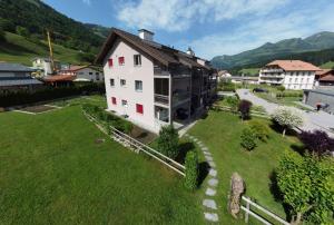 NeirivueGruyère Alpes Appartement 3 chambres BBQ Parking的绿色田野上白色房子的顶部景色