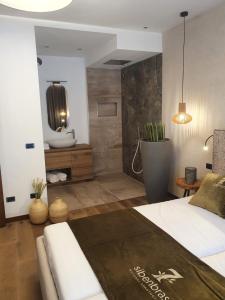 利莫内-苏尔加达Sibenbras Natural Aparthotel的一间带大床的卧室和一间浴室