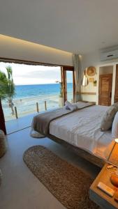 普雷亚Piticcaia Lodge - Casa pé na areia, Frente mar - PREÁ的一间卧室设有一张大床,享有海景