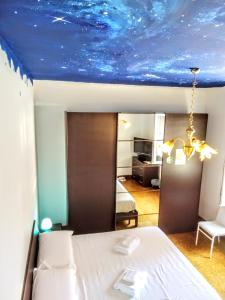 安佐拉德莱米拉Affittacamere di Andrea Bertolino Anzola dell'Emilia的一间卧室配有一张蓝色天花板的床