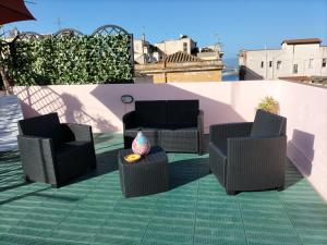 卡利亚里Rosa's Apartment with Terrace的屋顶上摆放着三把椅子和一张桌子