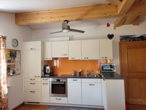 布鲁嫩Ferienwohnung Bally的厨房配有白色橱柜和吊扇