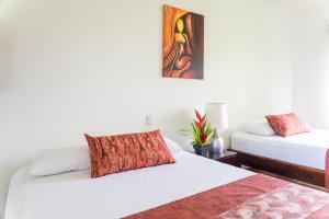 福尔图纳山景酒店的一间卧室设有两张床,墙上挂着一幅画