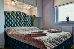 奥尔什丁Apartament32 Golden Vip -Duże Miejsce Postojowe-的一间卧室配有一张带软垫床头板的床和两个枕头