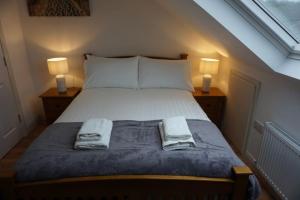 多尼戈尔Whitehorse House的一间卧室配有一张带两盏灯和毛巾的床。
