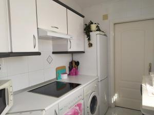 萨拉戈萨Apartamento junto a la Basilica del Pilar的厨房配有白色橱柜、洗衣机和烘干机