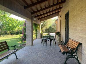 法诺Guest House Vagamondo的庭院设有长椅和桌椅
