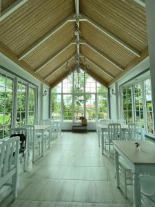 Kaeng KhoiMe and Tree Villa的客房设有桌子和白色的椅子以及窗户。