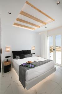 纳克索乔拉Naxos White Concept的白色的卧室设有一张大床和一个窗户