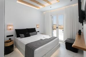 纳克索乔拉Naxos White Concept的白色的卧室设有床和大窗户