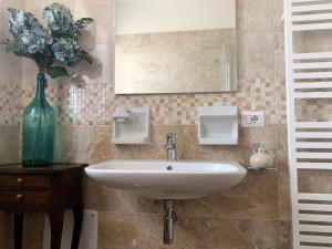 法诺Guest House Vagamondo的一间带水槽和花瓶的浴室
