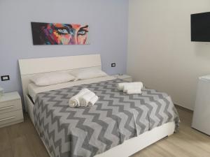 加利波利B&b tra scirocco e tramontana的卧室配有一张床,墙上挂有绘画作品