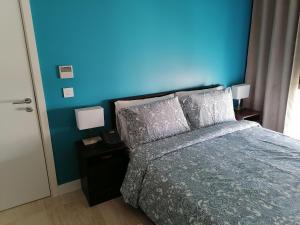 亚喀巴Blue Diamond Ayla - Restricted to Family stays的一间卧室设有蓝色的墙壁和一张带枕头的床。