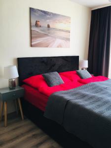 图尔钱斯凯特普利采apartmán MONYA的卧室配有红色的床,墙上挂有绘画作品