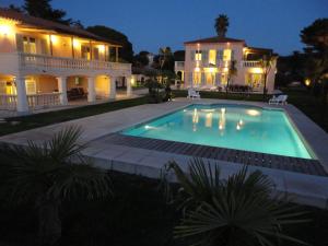 圣特罗佩Villa Playa del Sol - B2的夜间在房子前面的游泳池