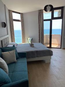 高尼奥Gonio Seaside Residence的一间卧室设有一张床和一张沙发,享有海景