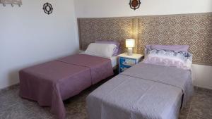 拉奥利瓦Casa Natura Ainhoa的一间卧室设有两张床和一张桌子上的台灯。