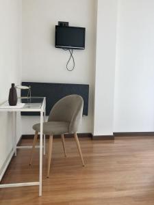 科尔库维翁阿兹霍腾希尔斯酒店的椅子和桌子,墙上有电视