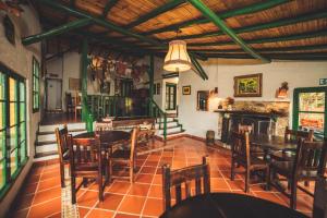 瓜斯卡圣安东尼奥牧场山林小屋的一间带桌椅和壁炉的用餐室