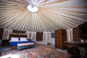 GulmitRoomy Yurts, Gulmit Hunza的蒙古包内一间卧室,配有一张床