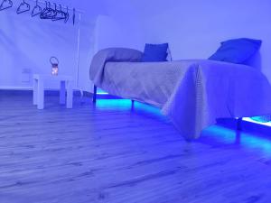巴里La Perla di Ele的一间卧室配有一张床和一张带蓝光的桌子