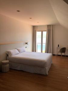 科尔库维翁阿兹霍腾希尔斯酒店的卧室设有一张白色大床和一扇窗户。