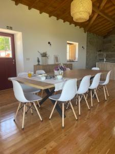 BrufeCasa do Afonso的一间带木桌和白色椅子的用餐室