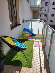 比亚韦斯托克Apartament Rainbow的一个带椅子的阳台和一个游乐场