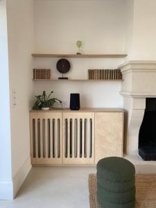 维桑La Source - Villa wissantaise的客厅配有木制散热器和椅子