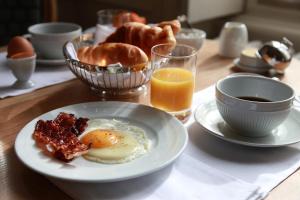 拉弗雷切Hôtel Le Gentleman的包括鸡蛋培根和橙汁的早餐桌